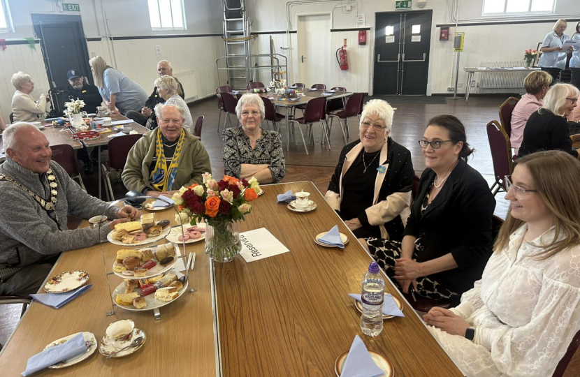 Rebecca enjoying tea and cake with the community