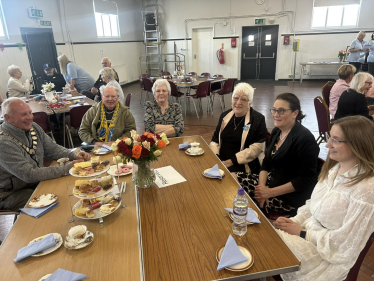 Rebecca enjoying tea and cake with the community