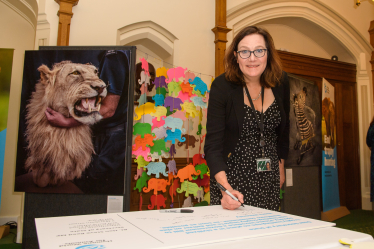 Rebecca signs giant postcard